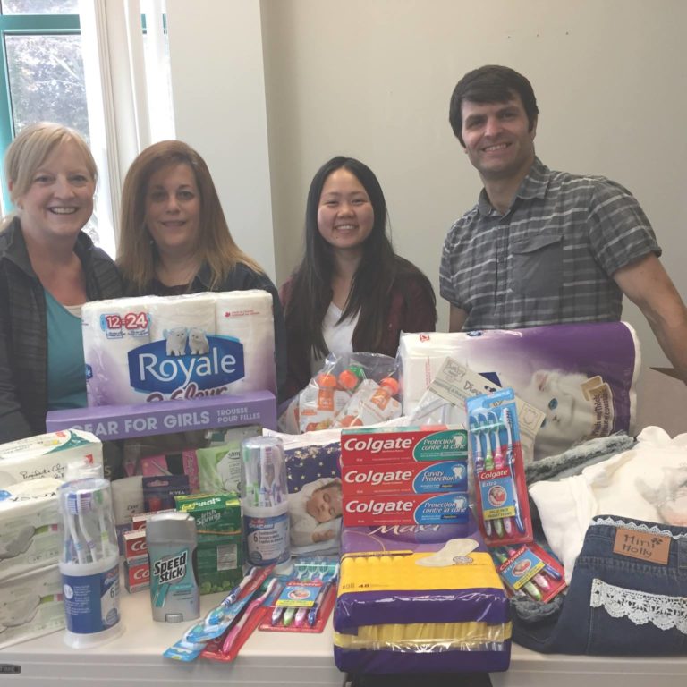 Staff in front of table with donated products