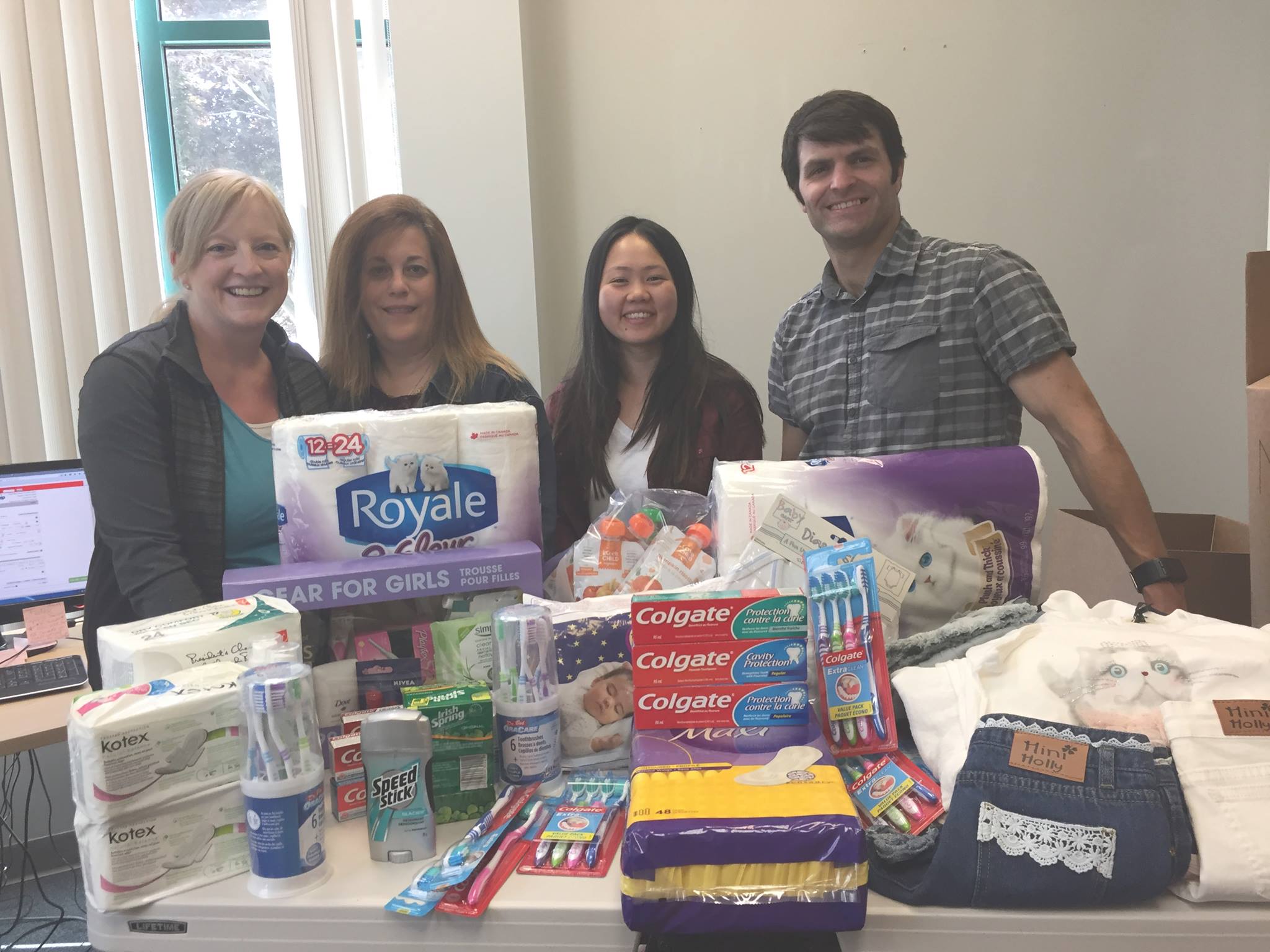 Staff in front of table with donated products
