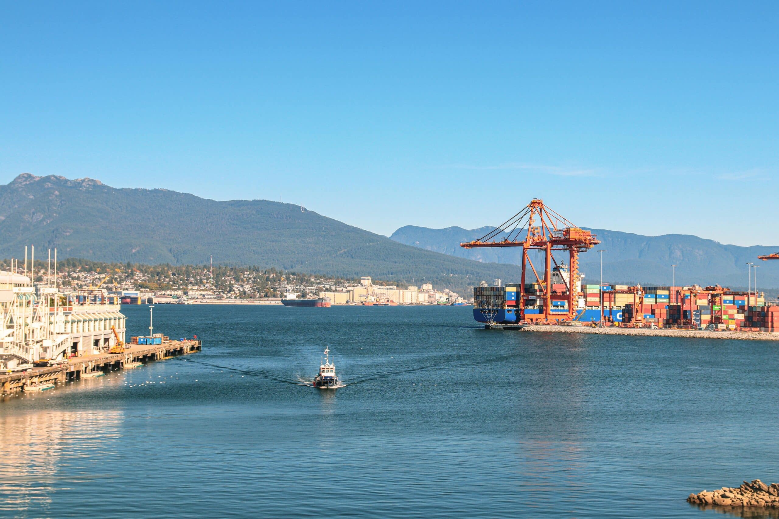 A boat passes a busy port and cross-dock facility.