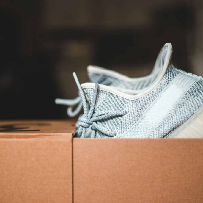 A new pair of sneakers sticking out of an open shoebox.