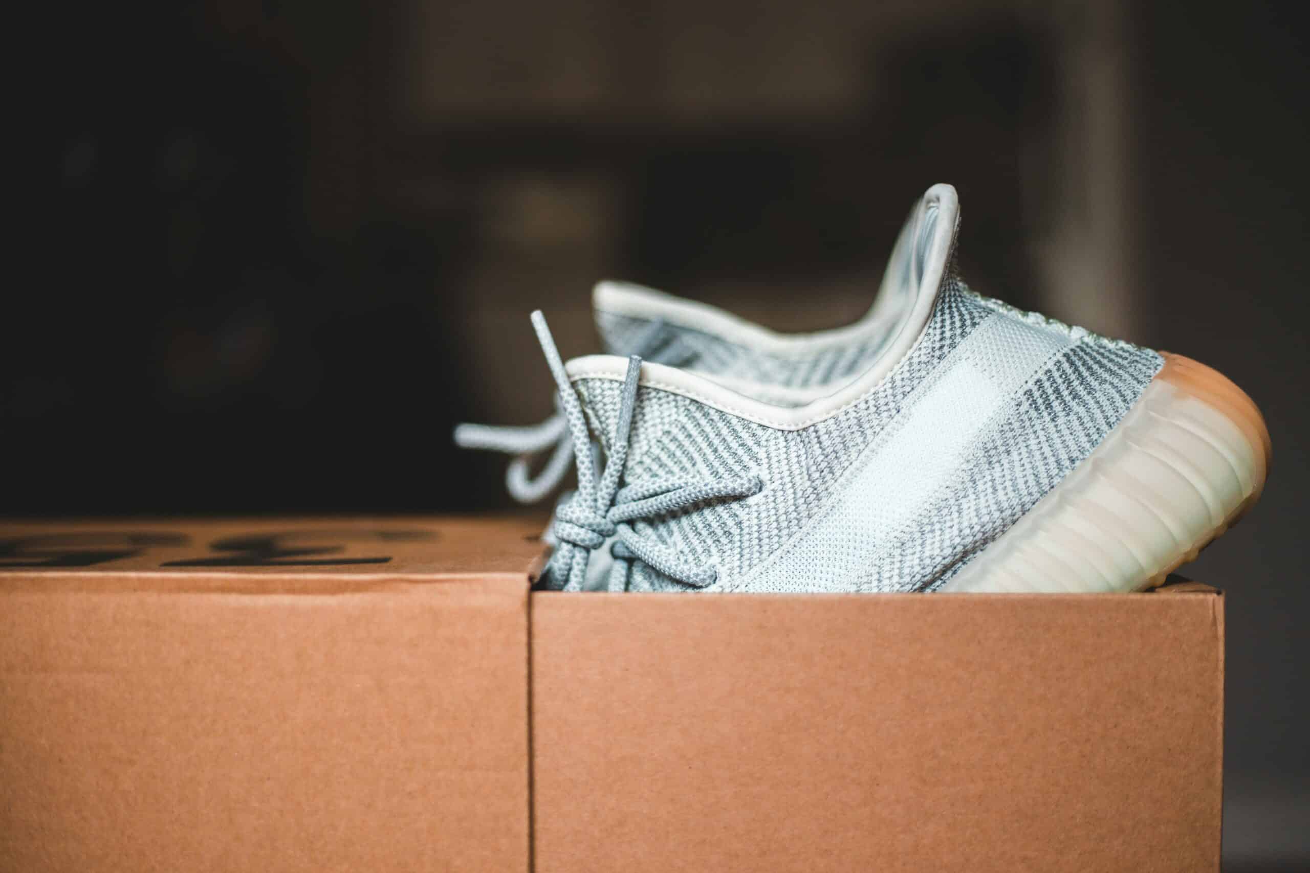 A new pair of sneakers sticking out of an open shoebox.