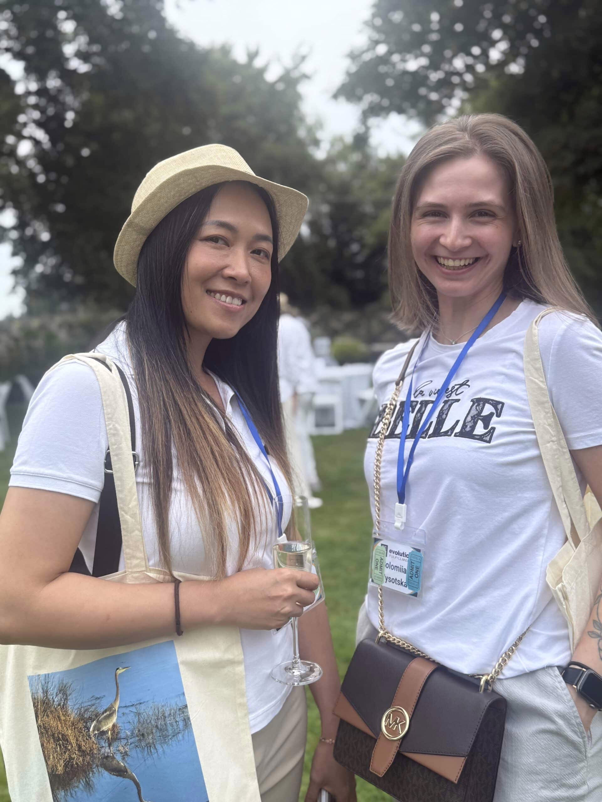 Two women smile and pose for a picture at a fundraising event.