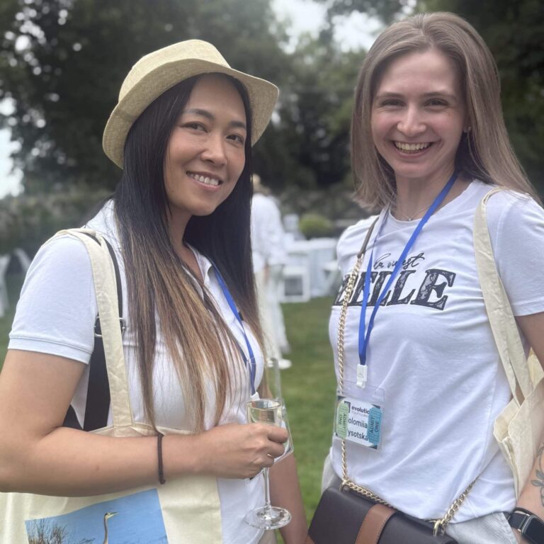 Two women smile and pose for a picture at a fundraising event.