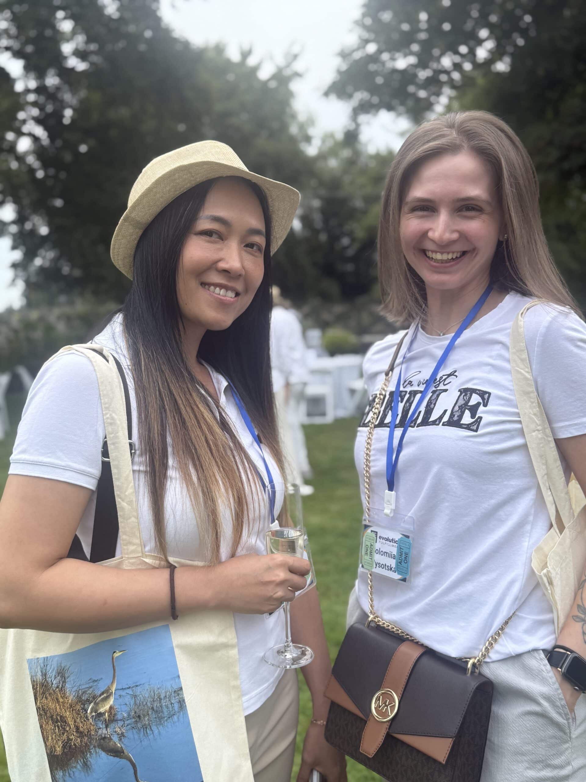 Two women smile and pose for a picture at a fundraising event.
