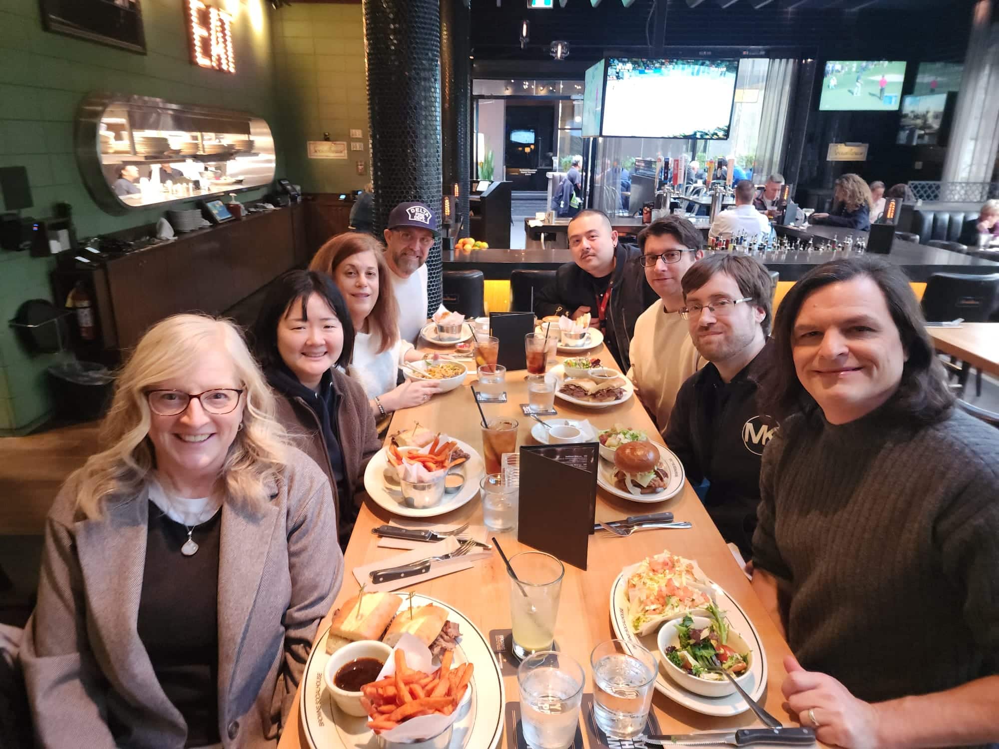 Evolution team members celebrating 10 years of employment, seated at a long table in a restaurant.